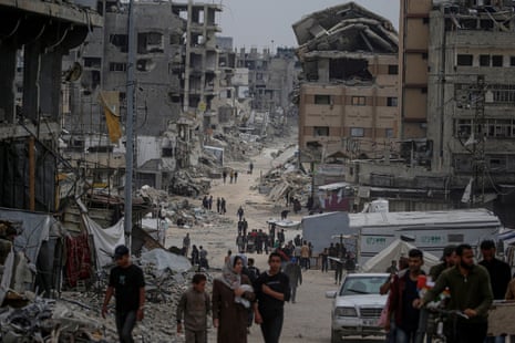 Internally displaced Palestinians move in the streets of Al Shejaeya neighbouhood in the east of Gaza City on Monday.