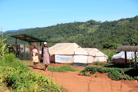 Women in Ngangu, Chimanimani, walk past tent shelters