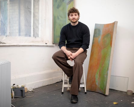 Leon Scott-Engel surrounded by paintings in his simple studio space