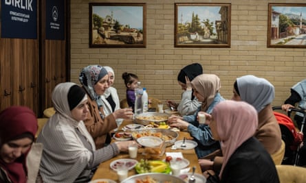 زنان تاتار کریمه افطار می خورند، غذای روزه ای که مسلمانان در ماه رمضان در مرکز فرهنگی بیرلیک در کیف در آوریل 2023 برگزار می کنند.