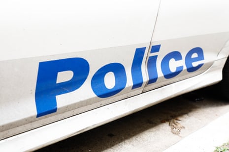 A blue police logo on a white car.