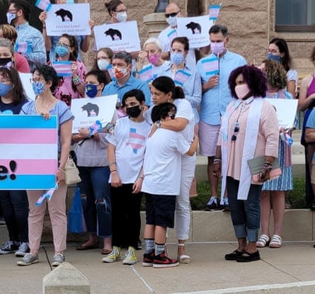woman hugs child amid crowd protesting for trans rights