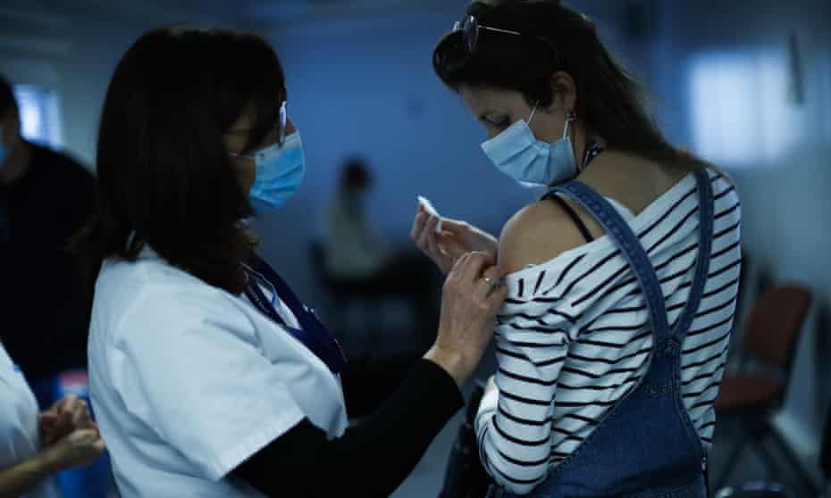 A nurse administers a Covid-19 vaccine to a healthcare worker in Liege, Belgium, 27 January 2021.