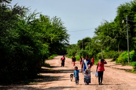 Wichi Indigenous women and children walk along a road in Mision Chaquena, near the town of Embarcacion, Salta Province, Argentina