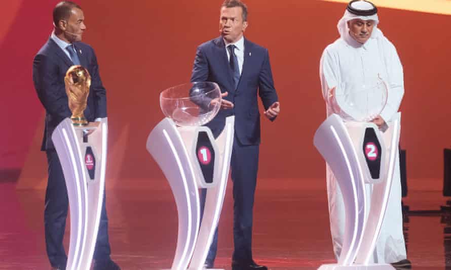 Cafu (à gauche) et Lothar Matthäus (au centre) avec l'ancien footballeur qatari Adel Ahmed Mallala sur scène lors du tirage au sort de la Coupe du monde à Doha, au Qatar.