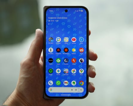Google Pixel 10 Pro Fold closed and held in a hand showing the home screen full of apps.