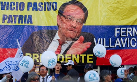 People stand in front of a banner bearing the image of murdered presidential candidate Fernando Villavicencio in Quito, Ecuador