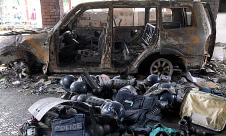 Damaged riot gear of security forces is seen next to a burnt vehicle outside a police station in Dhaka.