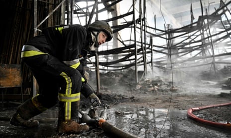 A Ukrainian firefighter works to put out a blaze in a shopping mall on Thursday after Russian shelling in Kherson, southern Ukraine