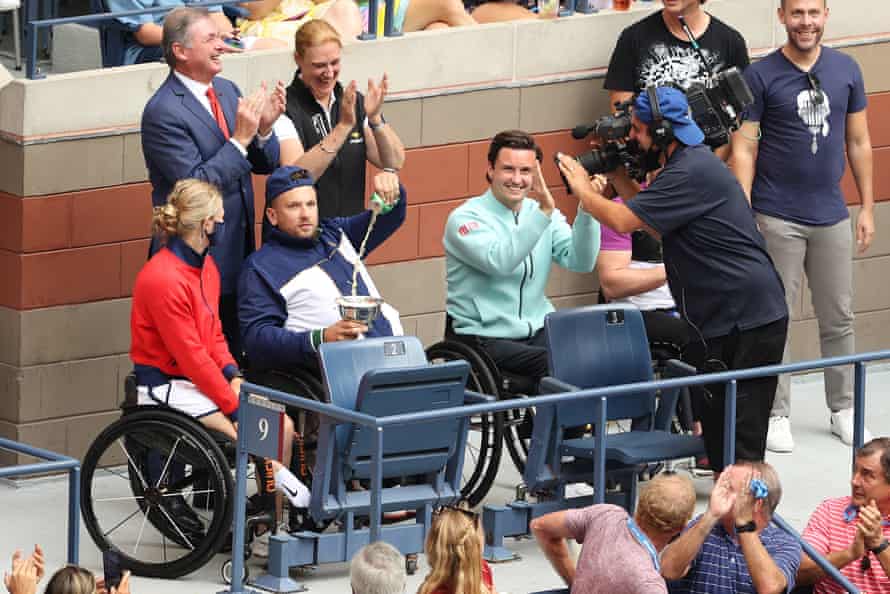 Dylan Alcott pours a beer next to Diede de Groot