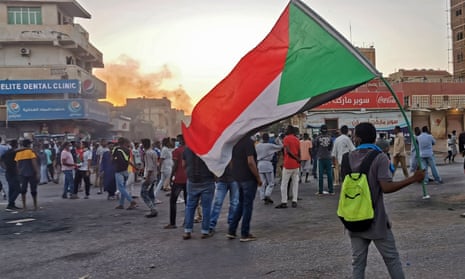 Sudanese anti-coup protesters in Khartoum, one carrying flag