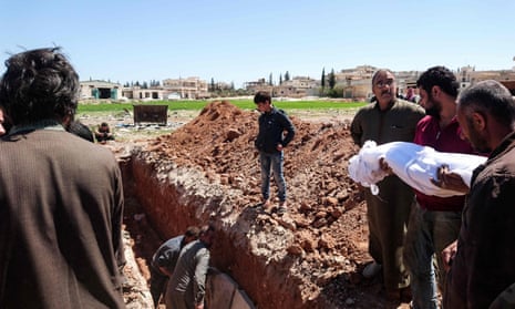 Syrians bury the bodies of victims of a toxic gas attack in Khan Sheikhun, in April 2017. 