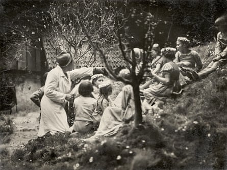 Murnau, left, directs a group of children on a grassy hillside during the filming of the Gretchen sequence.