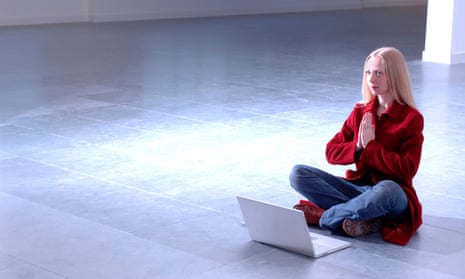 young woman sitting on floor with computer making prayer gesture