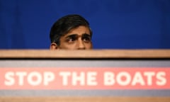 Rishi Sunak's head peeks above a sign that reads 'stop the boats'