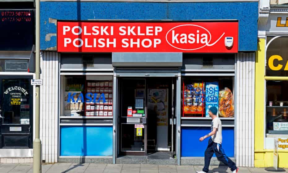 Man walking past Polish shop in Scarborough, North Yorkshire.