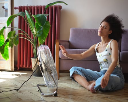 A woman sitting in front of a portable fan