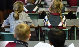Children sit in a classroom during a lesson