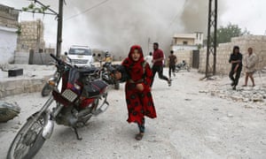 Sírios correr para se esconder durante um ataque aéreo em Idlib em 30 de maio.