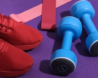 Red sports shoes, dumbbells, fitness rubber bands on purple sports mat. Workout concept.