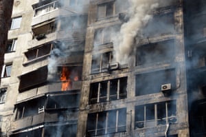 Smoke comes out of the windows in a residential building shelled by the Russian troops