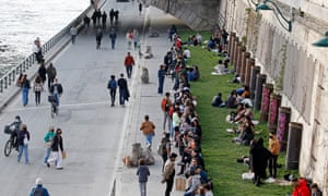 People gather on the banks of the Seine in Paris before the curfew which starts at 6 pm.