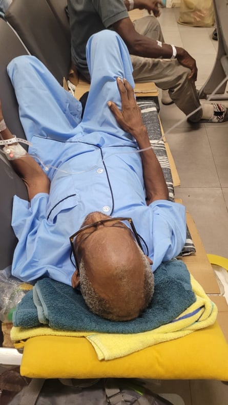 Medical patient lying down on a row of chairs in a hospital
