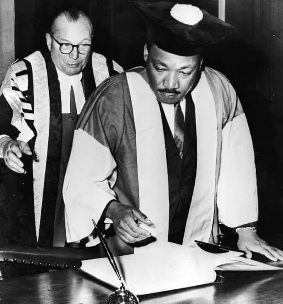 American civil rights leader Dr Martin Luther King, watched by Dr Charles Bousenquet, signs the degree roll At Newcastle University in 1967. 