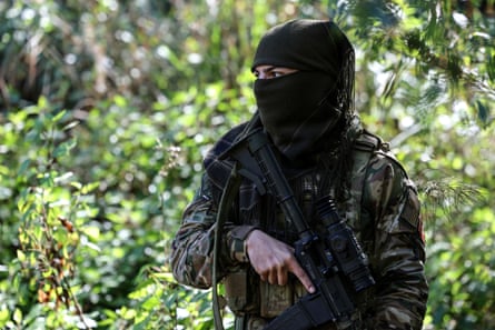A man in camouflage military clothes and balaclava