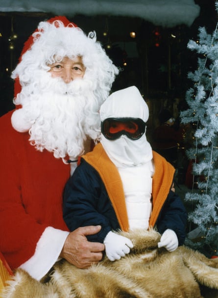 A young Nihal sat on Santa’s knee wearing a hood and ski goggles