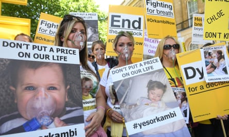 Campaigners wearing oxygen masks hold banners during a protest over the lack of availability of a ‘life-saving’ cystic fibrosis drug Orkambi in central London, Britain, 26 June 2017