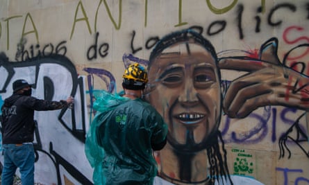 A demonstrator creates a mural with a portrait of Nicolás Guerrero.