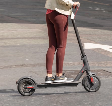 A woman riding an electric scooter in London