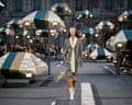A model walks the Louis Vuitton runway lined with striped domed lamp sculptures