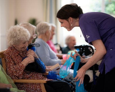 A care worker talks to a woman in a care home