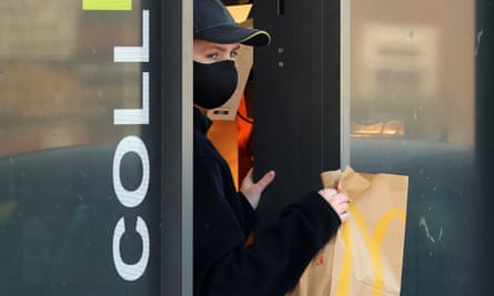 An employee wears a mask to serve customers at a McDonald’s drive-thru near Dover in Kent.