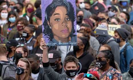 A protestor brandishes a portrait of Breonna Taylor during a rally in remembrance in March 2021 on the first anniversary of her death in Louisville, Kentucky.