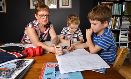 Zoe Collins helps with school work with Dare, age 5, and Douglas, age 7, at their home in Brisbane, in 2020. One academic says a number of different factors impact whether a student struggles during learning from home.