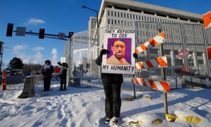 دو تاو جونيور ، ثلاثة ضباط سابقين في شرطة مينيابوليس متهمين بانتهاك الحقوق المدنية لجورج فلويد عندما شارك في عملية اعتقال جورج فلويد في عام 2020.  وقف المتظاهرون خارج المحكمة الفيدرالية قبل بدء مرافعات المحاكمة المدنية لألكسندر كوينج وتوماس لين.