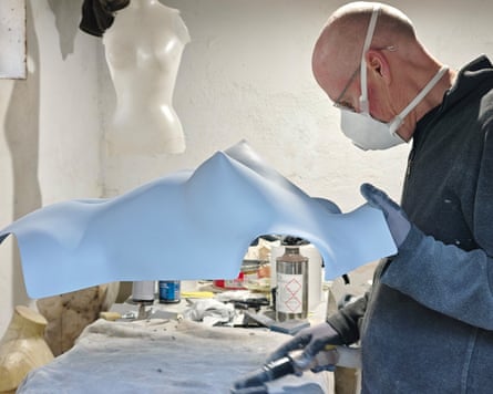 Patrick Whitaker holding the breastplate in a workshop