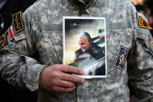 A demonstrator holds the picture of Soleimani during a protest in Tehran