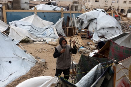 Displaced Palestinians inspect their tent after it is damaged by a storm at a displacement camp in Gaza City on 13 January 2026.
