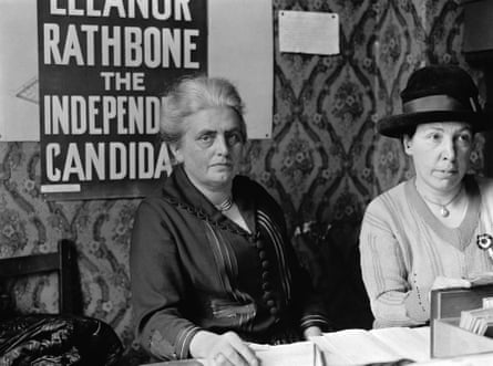 Black and white photograph of Eleanor Rathbone sat in front of her independent candidate campaign sign.