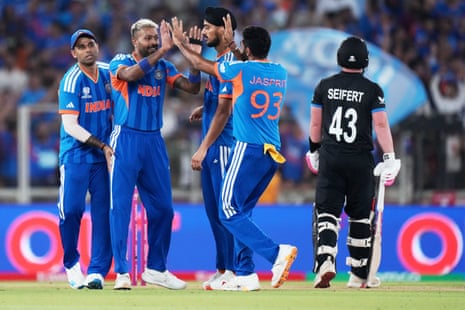 India's Hardik Pandya, second left, celebrates with teammates after taking the wicket of New Zealand's Mark Chapman.