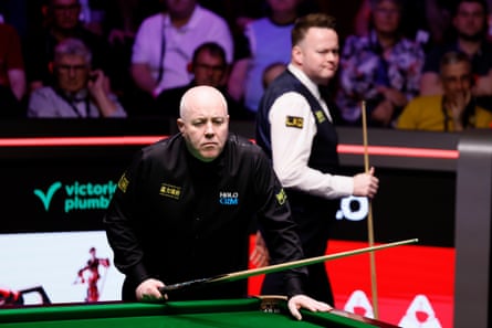 John Higgins (left) att he table with Shaun Murphy (right) behind him during their semi-final at the Crucible.