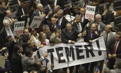 Deputies from opposition parties carry a banner that reads ‘Temer Out!’ during a vote by the lower chamber of Brazil’s Congress in Brasilia, Brazil Wednesday.