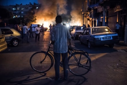 Damascus, August 2013: A cyclist watches the fire caused by an exploded mortar.