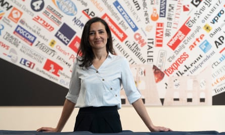 Esma Cakir, the president of the Foreign Press Association in Italy, in front of a collage of different newspaper titles.