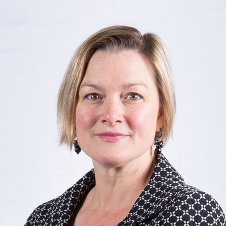 A young middle-aged white woman with chin-length blond hair and a black and white patterned blazer.
