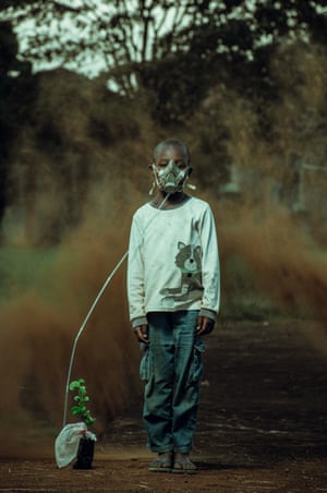 A young boy holding a tree seedling with one of its leaf wrapped on a polythene bag, a straw comes out seemingly from his nostrils to the bag as though is giving it air